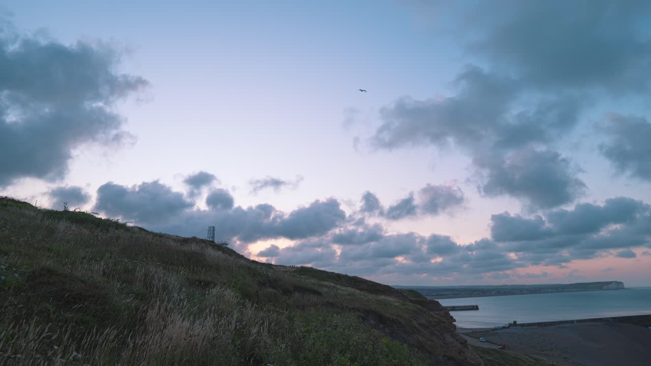 A serene landscape at sunrise against the cloudy sky on a grassy hillside —tranquillity embodied in nature’s beauty