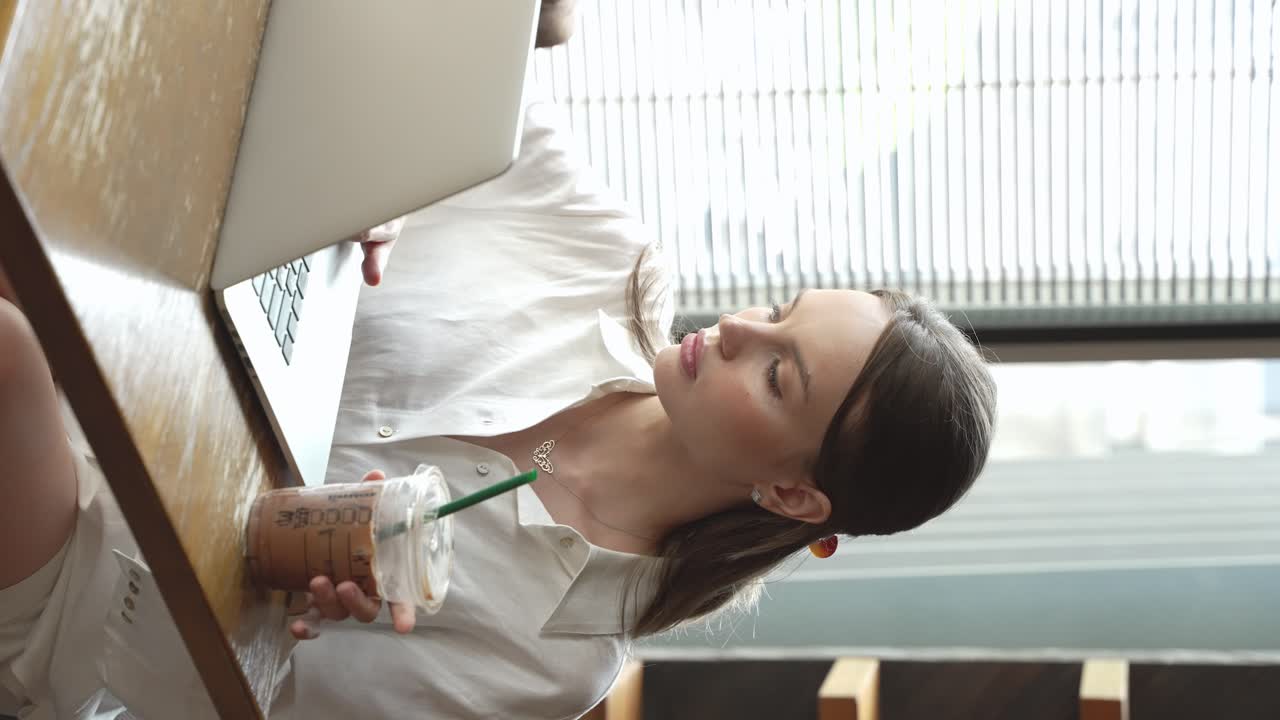 mujer trabajando en una computadora portátil en un café