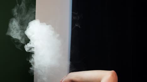 una nube de humo de un cigarrillo electrónico contra una pared