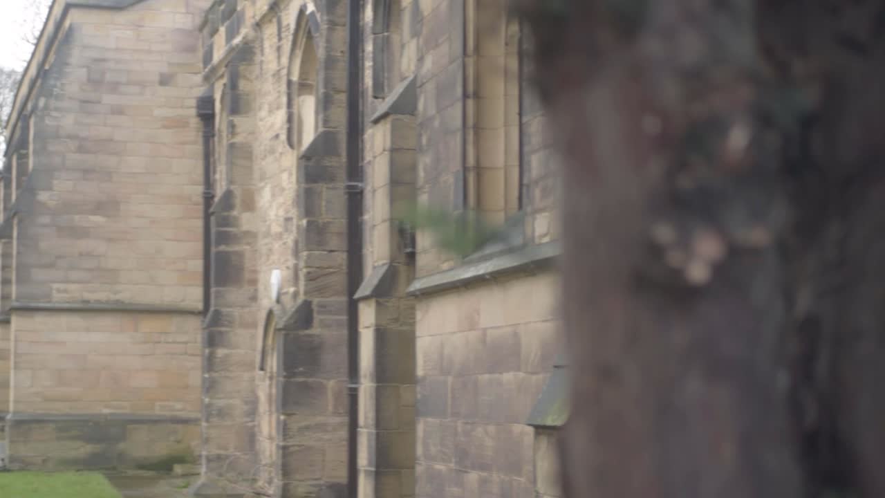 View of old stone built English Church through tree