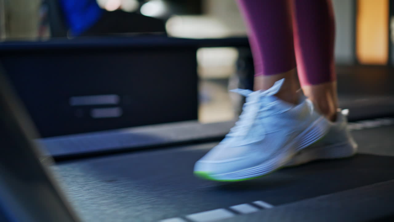 Athlete feet walking jogging machine at sport workout closeup. Woman training