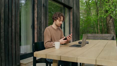 man working from a cabin on a wooden deck