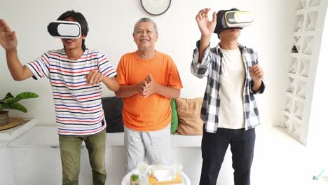 happy asian father and sons playing video games with vr glasses and giving high five to each other