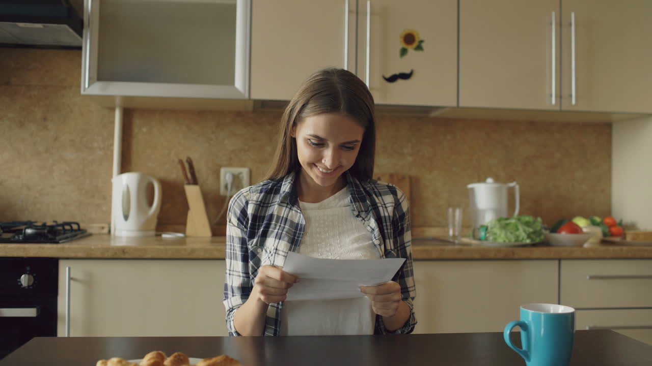 Woman Reading a Letter in Kitchen