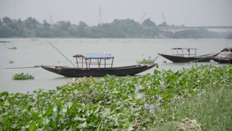 empty boats near river bank of ganga, rani rashmoni ghat, bridge seen far away, slow motion