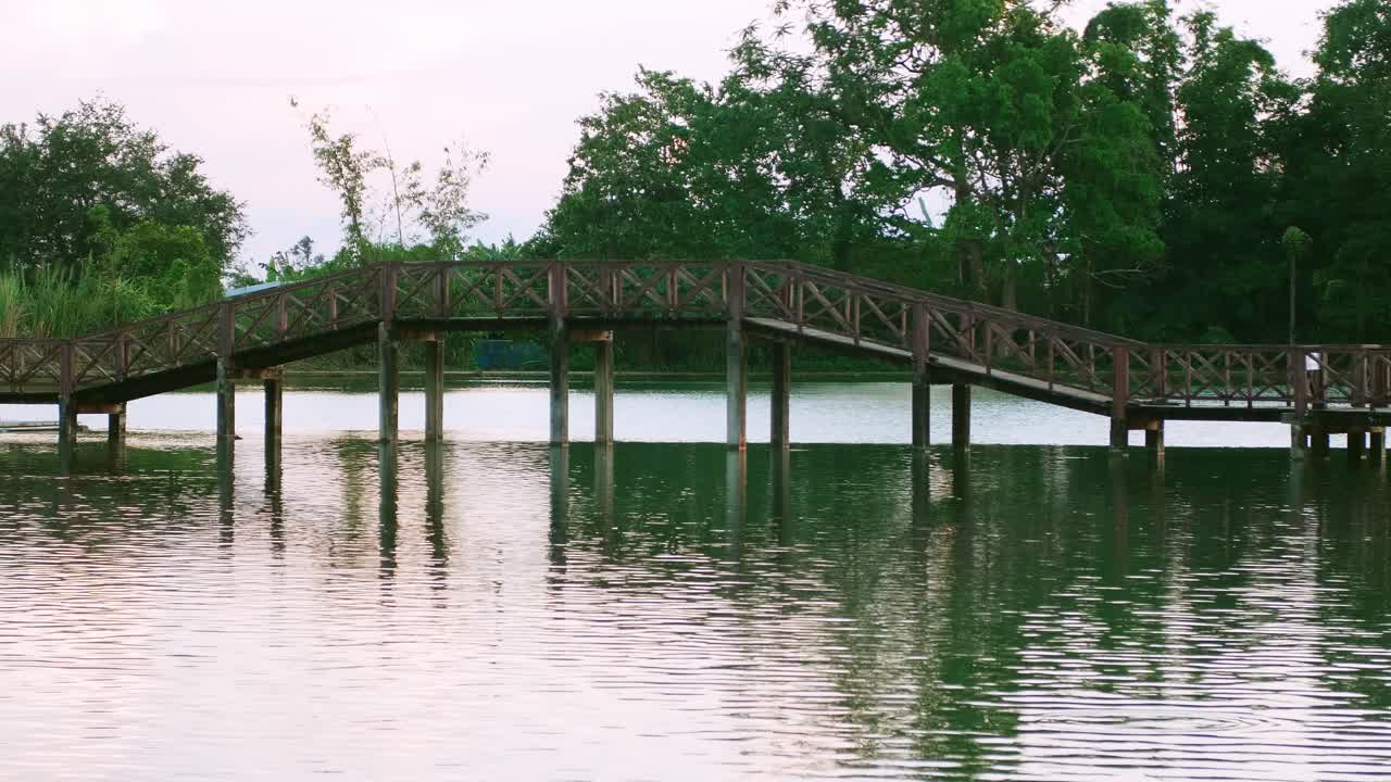 pasarela de puente de madera en el paisaje del lago atracciones naturales al atardecer