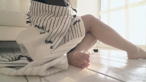 mujer de primer plano con cuadros se relaja en la ventana a la luz del sol