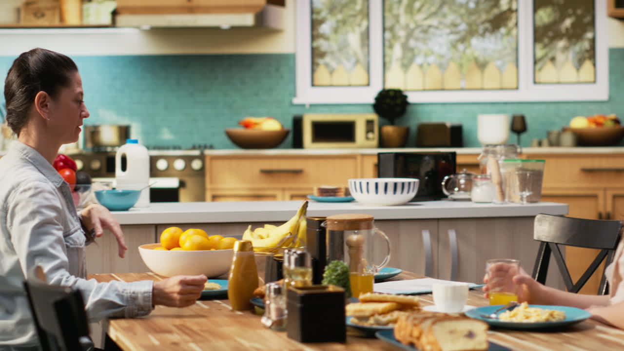 Distracted busy father studying some papers during breakfast meal