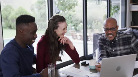 Happy-diverse-couple-and-male-financial-advisor-using-laptop-and-discussing-at-home,slow-motion