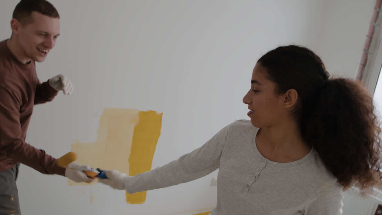 Happy Couple Painting Their Home Together