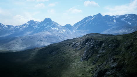 aerial over valley with snow capped mountains in distance