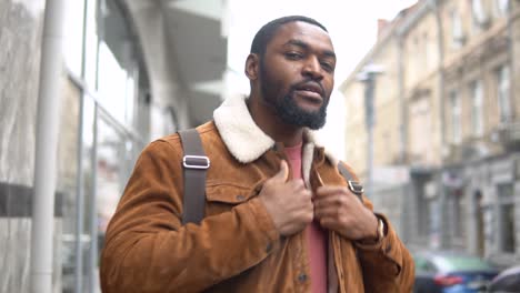 bearded black man stands outdoor near the office center