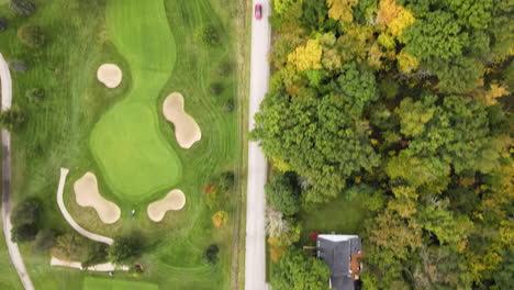 aerial top down view along straight rural countryside road route in autumn season, path through green golf fields lands trees and country homes, nature and landscape in pelham region ontario canada