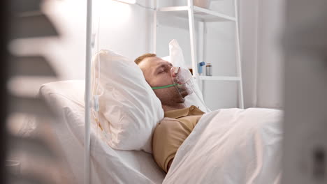 man coughing in hospital bed