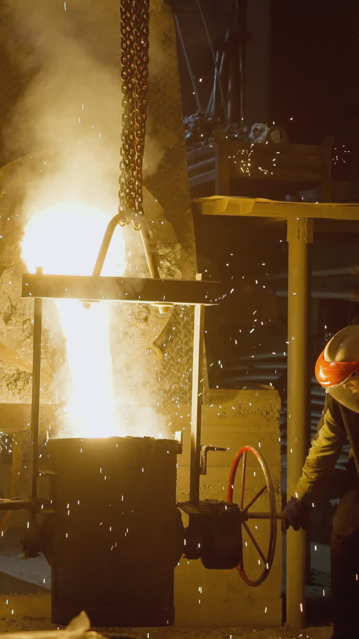 рабочие литейного завода в действии наливают расплавленную сталь огненными искрами