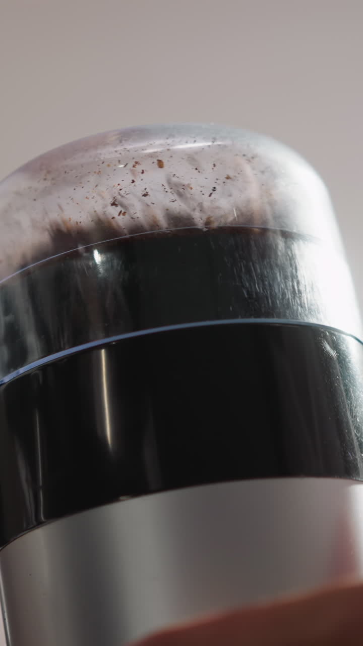 부인이 커피 콩을 는 기기 클로즈업. 은 옷을 입은 여자가 주방 기기로 곡물을 는. 맛있는 카페인 음료를 만드는 과정