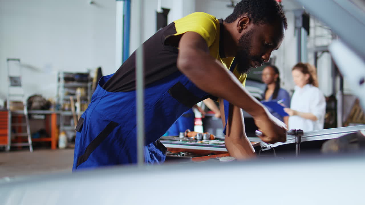 Technician replaces car engine in garage