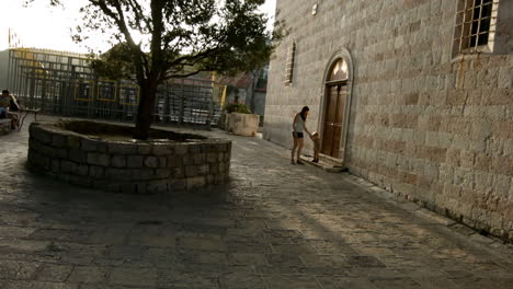 mother and child walking in old town square