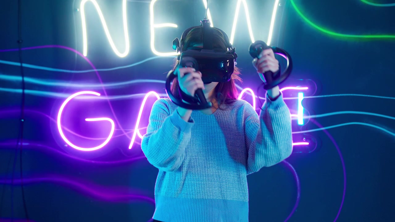 Giovane donna che gioca a un gioco di realtà virtuale in una stanza illuminata al neon