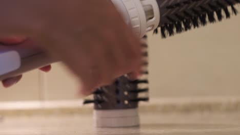 woman using a hair dryer and brush