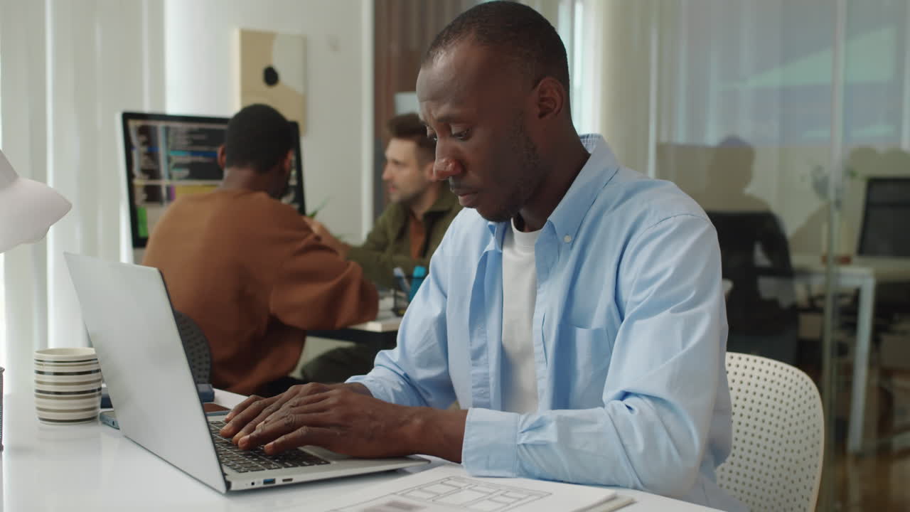 Serious Coder Testing Application on Laptop at Office