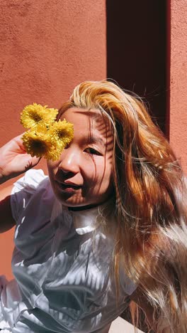 mujer con flores amarillas y luz del sol