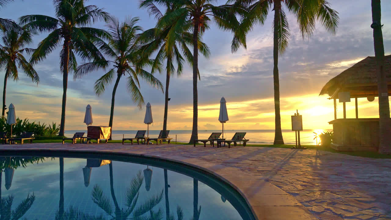 sombrilla y silla alrededor de la piscina en el hotel resort para viajes de placer y vacaciones cerca de la playa del océano al atardecer o al amanecer