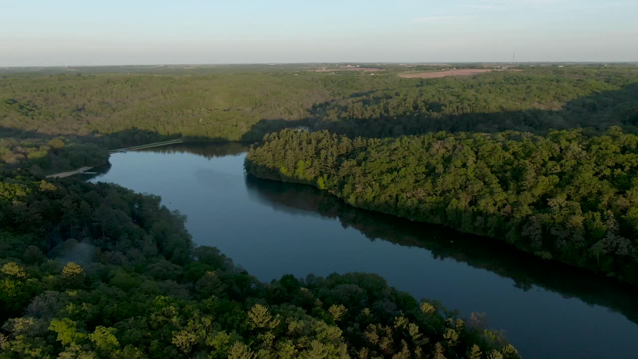 drone disparó a gran altura de un lago en las montañas rodeadas de un espeso bosque en wisconsin, estados unidos, durante la puesta de sol
