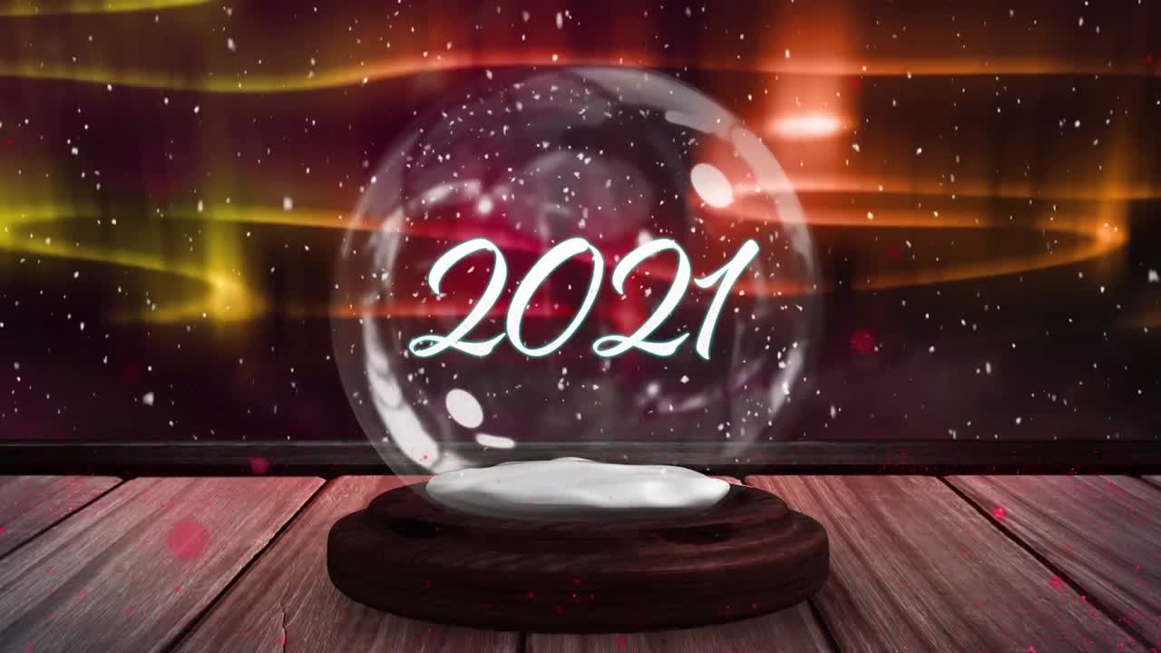 animación digital de una estrella fugaz girando con el texto de 2021 en un globo de nieve contra una luz brillante