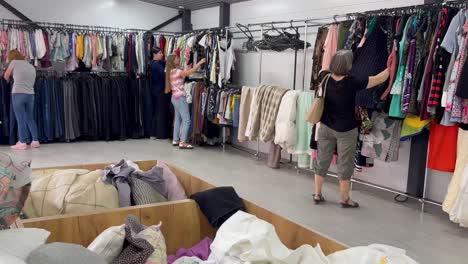a group of people shopping at a second-hand store. used clothes. fashion for retro clothes.