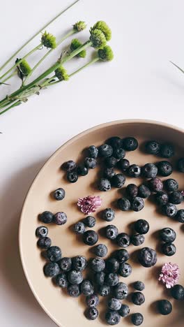 blueberries in a beige bowl with flowers