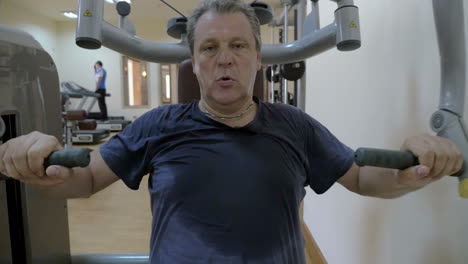 sweaty man working out on exercise machine