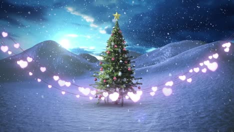 Heart-shaped-fairy-lights-decoration-against-snow-falling-over-christmas-tree-on-winter-landscape