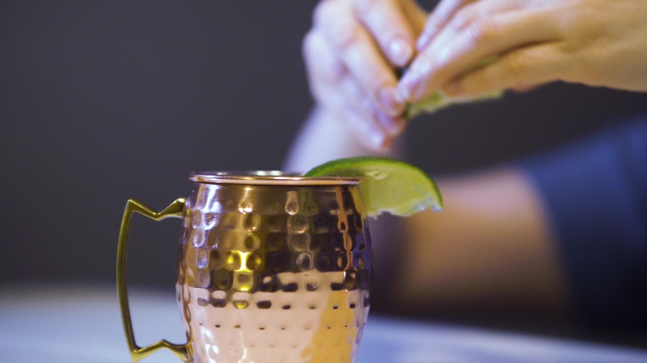 hand squeezed lime on Moscow Mule cocktail in typical copper mug