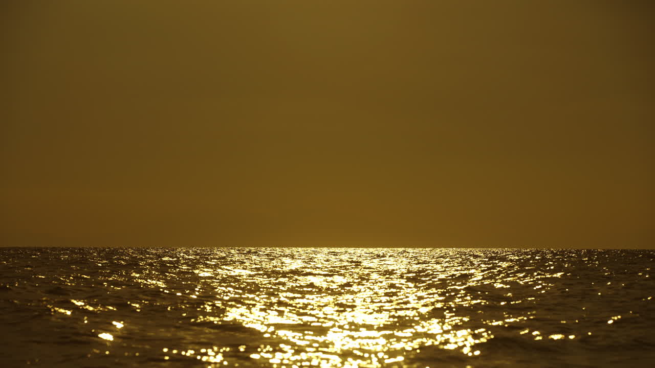 바다 위에서 황금빛 해가 지는 것