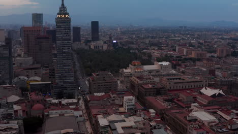 Tilt-up-shot-of-cityscape-with-view-of-Torre-Latinoamericana-tall-building.-Town-after-sunset.-Mexico-City,-Mexico.