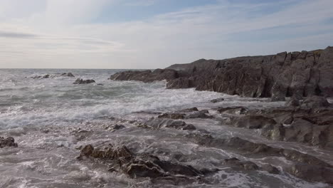 Waves-Crashing-Against-a-Rocky-Cove-on-a-Summer’s-Evening-in-Slow-Motion