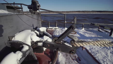 winter scene of a tugboat deck with snow and mooring equipment