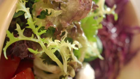 close-up of a fresh falafel wrap or bowl with tomatoes, lettuce, and sauce