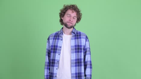 un joven guapo, barbudo y hipster con el cabello rizado.