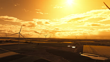 silhouette wind turbines collecting wind to create electricity at sunset. - aerial shot