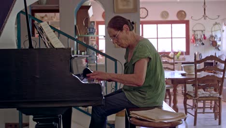 old woman playing a grand piano at her home