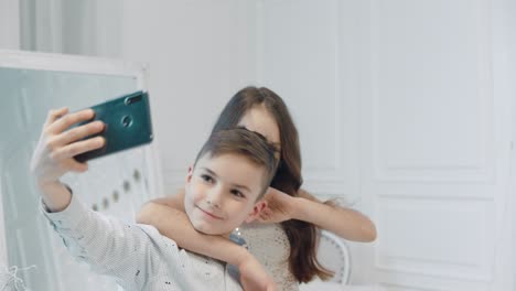 smiling boy and girl making fun for selfir photo together.