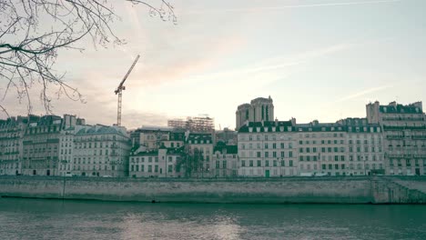 arquitectura parisina a orillas del río sena, diseño antiguo y similar de edificios, puesta de sol en el fondo