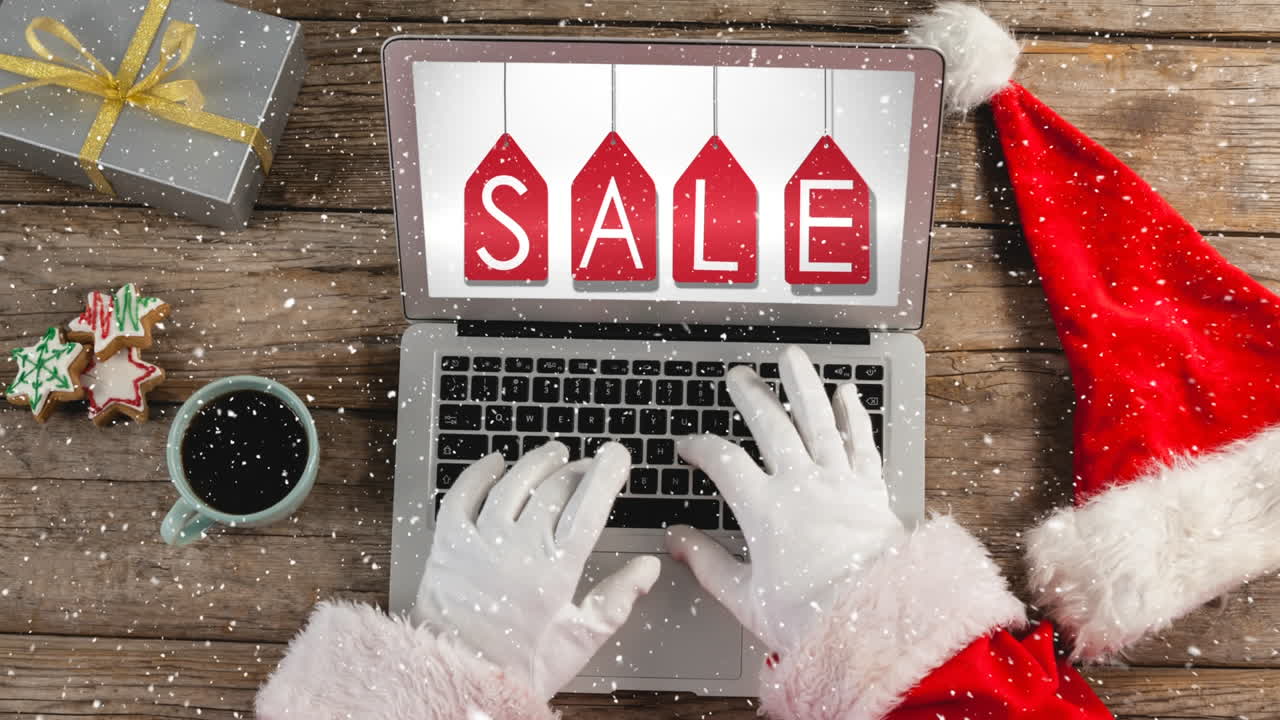 노트북에 산타의 손을 가지고 책상 위에 눈을 가진 비디오 구성