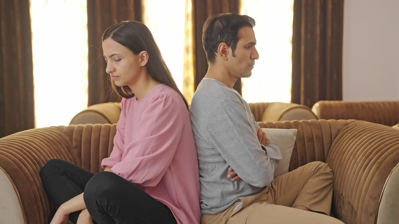 una pareja enojada sentada de espaldas y sin hablar