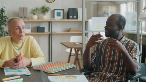 African-American-Businessman-in-Wheelchair-Speaking-with-Female-Colleague-in-Office