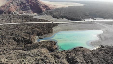 rotation over a small lake in lanzarote revealing the volcanos land behind