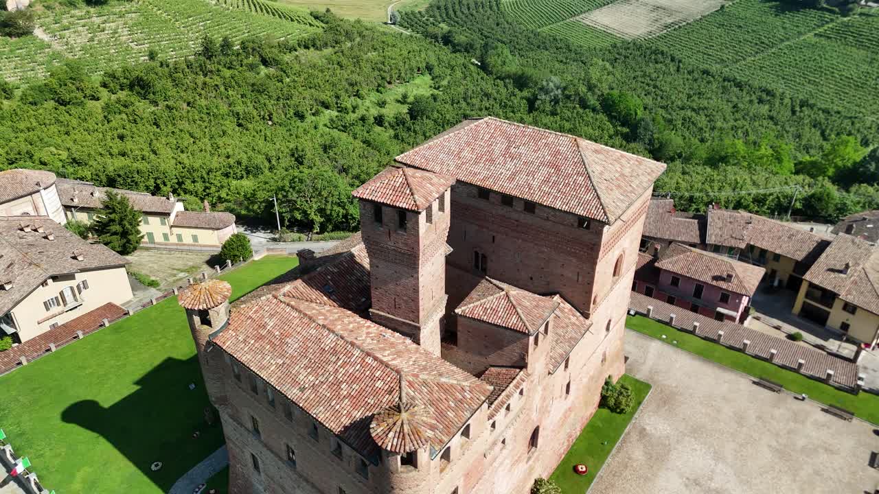 Grinzane Cavour castle, UNESCO site, Cuneo, Piedmont, Italy. 4k aerial view of the castle together with the Vineyard. Langhe-Roero and Monferrato. Tilt up ascending close to the castle