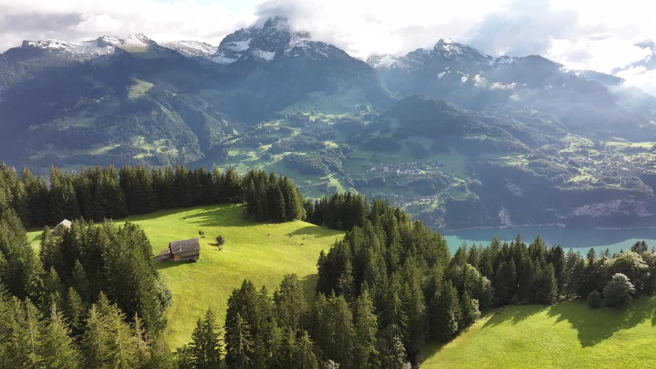 A sweeping aerial view of the mountainous range in Amden, Weesen, Switzerland, gradually unveils the serene beauty of Lake Walensee below.